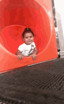 A heartwarming moment captured as a toddler confidently waves goodbye before sliding down.