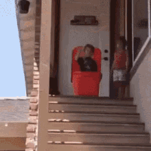 A kid pushing another kid in a box down the stairs resulting in comedic chaos.